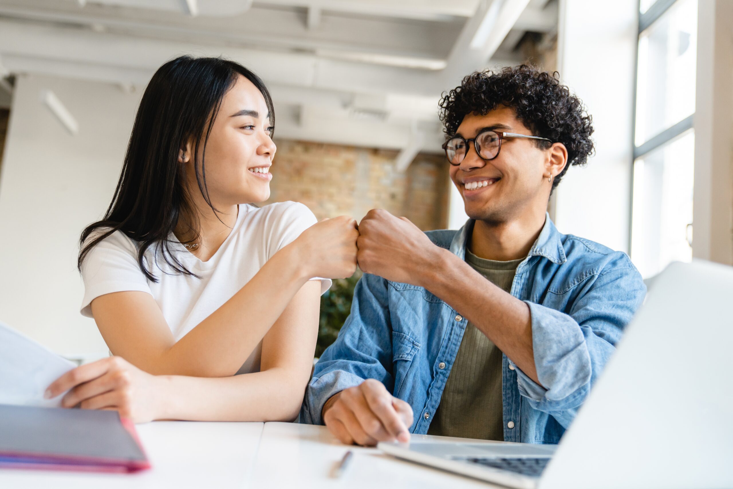 Happy,Colleagues,Business,Partners,Friends,College,Students,Classmates,Giving,Fist Two people fist bumping each other as they celebrate